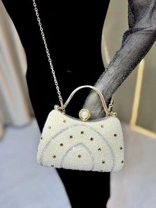 Détail d'un sac de soirée en perles luxueux avec strass et poignée en métal doré