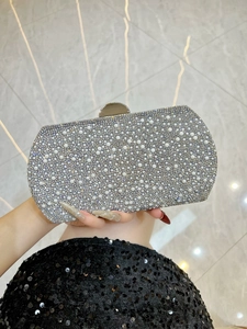 Detail of silver evening clutch featuring sparkling rhinestones and elegant pearls