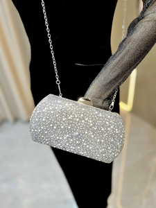 Macro detail of luxury evening clutch bag with white pearls and sparkling rhinestones