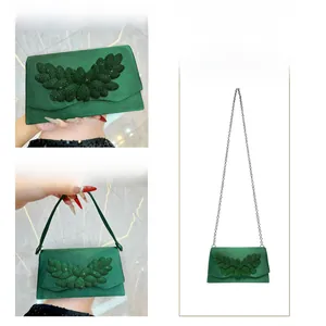 Detailed views of emerald satin evening clutch bag with crystal leaf design and chain strap