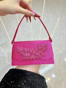 Detail of rose pink satin evening bag featuring intricate pink rhinestone floral patterns