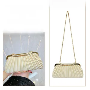 Detail of champagne pleated evening clutch with crystal clasp and detachable gold chain