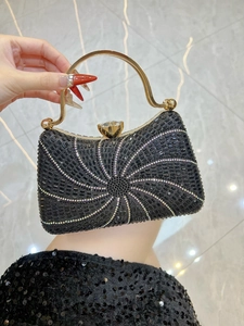 Détail d'un sac de soirée noir de luxe avec motifs en strass et poignée dorée élégante