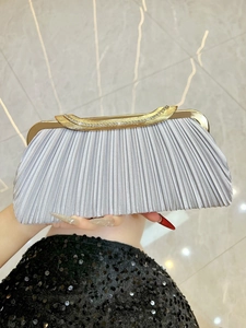 Detail of silver pleated evening clutch with rhinestone inlay and golden frame