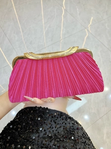 Detail of fuchsia pleated evening clutch featuring diamond-encrusted gold metal frame