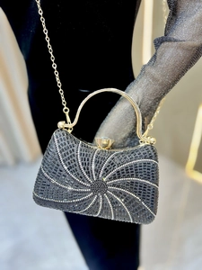 Détail de la pochette de soirée en strass noirs avec motif spirale et chaîne dorée