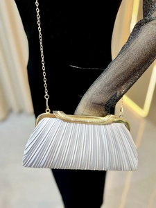 Detail of silver pleated evening clutch bag with rhinestone metal frame and gold chain