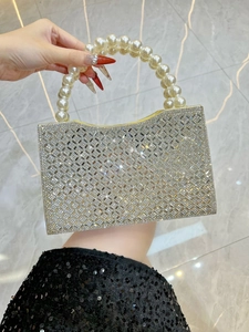 Macro detail of sparkly rhinestone evening clutch bag with elegant pearl handle