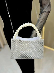 Detail of silver evening clutch bag with sparkling rhinestones and elegant pearl handle