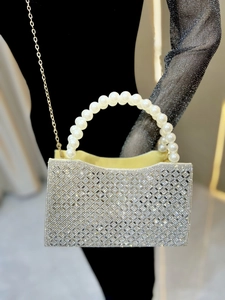 Macro detail of silver rhinestone grid evening bag with large pearl top handle