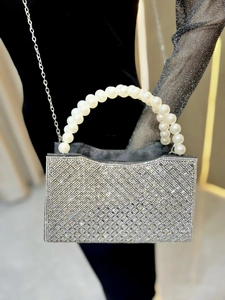 Detailed shot of sparkling rhinestone evening bag with elegant pearl handle and chain