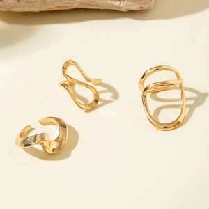 Macro detail of gold irregular hollow curved rings set with polished finish