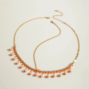 Détail d'un bijou de tête doré bohème avec charmes œil turc orange et cristaux