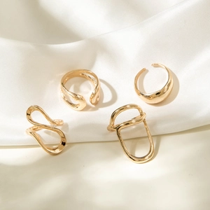 4-piece minimalist irregular hollow gold rings set on elegant white silk background