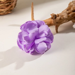 Detailed macro view of purple satin fabric flower hair clip with layered petals