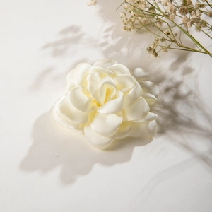 Detail of cream white satin camellia hair clip with elegant silk texture and fabric petals