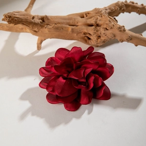 Elegant wine red satin camellia flower hair clip for women on rustic wooden branch