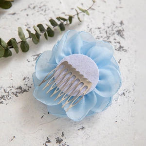 Macro shot of light blue chiffon flower hair comb with silver eight-tooth metal clip