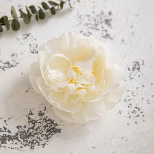 Detailed close-up of a white silk camellia hair clip with delicate fabric petals