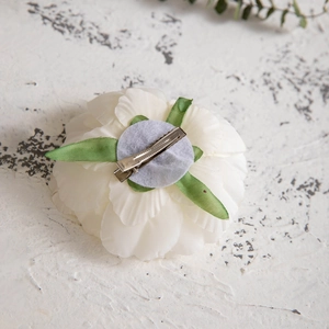 Detail view showing the back structure of white fabric flower hair clip with silver duckbill clip