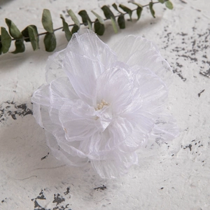 Detailed macro view of white fabric camellia hair clip with delicate pearl stamen details