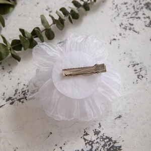 Detailed back view of white tulle flower hair clip showing silver metal duckbill clip attachment