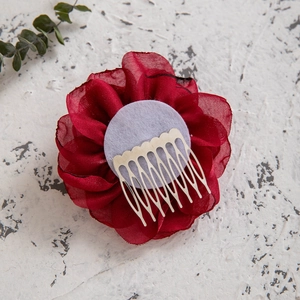 Macro detail of red chiffon flower hair clip with a silver metal duckbill comb back
