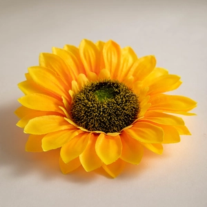 Detailed close-up of a vibrant yellow silk sunflower head with realistic fuzzy brown core