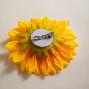 Macro view of sunflower hair clip showing the silver metal alligator clip and felt backing