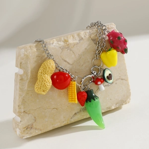 Detailed close-up of bohemian vegetable charms including avocado and corn on silver chain