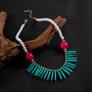 Détail du collier de perles bohème avec pendentifs en éventail turquoise et rouge