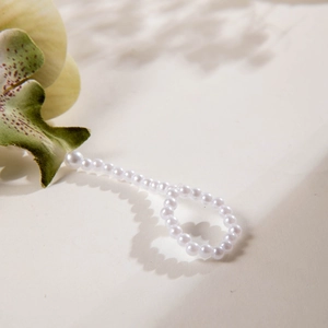 Macro detail of glossy white 3D printed orchid pearls with natural light shadows