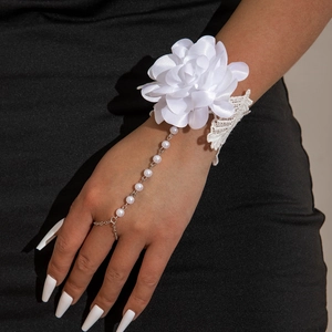 Detailed view of white 3D orchid fabric flower with pearl finger chain and lace details