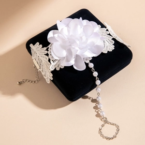 Macro detail of 3D orchid flower slave bracelet with pearls and lace on black velvet box
