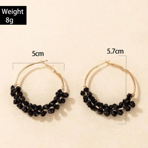 Détails des créoles dorées avec perles noires en diamètres de 5 cm et 5,7 cm