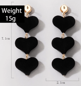 Détail de longues boucles d'oreilles cœurs floqués noirs, dimensions 7,1cm par 2,1cm