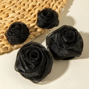 Gros plan de roses en tissu mesh noir avec paillettes et pétales multicouches