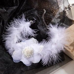 Detailed macro view of white feather choker with elegant fabric flower and silver chain clasp