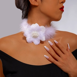 Close-up of elegant white floral choker with feathers and beads on fashion model neck