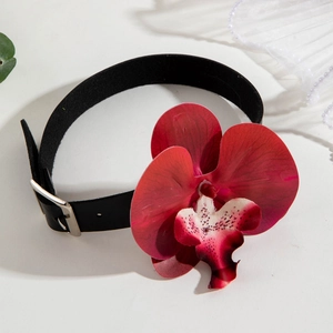 Detail of elegant black choker with large deep red orchid flower and silver buckle