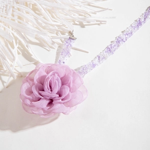 Detail of elegant purple tulle flower choker with delicate beaded chain for women