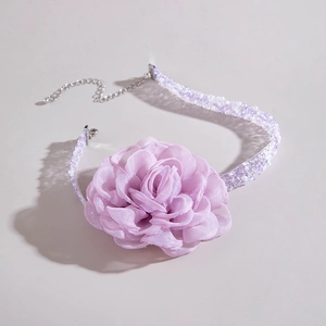 Macro detail of lavender fabric flower choker with woven beaded chain and silver clasp