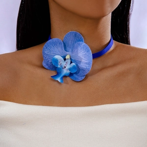 Detail of blue orchid choker necklace with realistic petals and soft velvet strap
