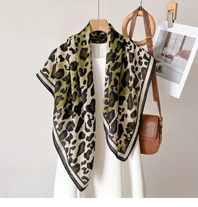 Detailed view of leopard print silk scarf draped over a white dress for styling