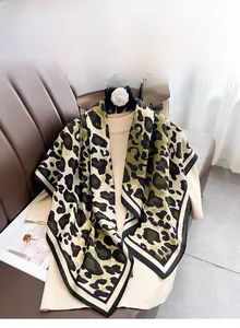Detailed view of leopard print silk scarf draped on clothing with machine-stitched edges