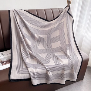 Detail shot of lightweight striped scarf draped on a leather sofa showing fabric texture