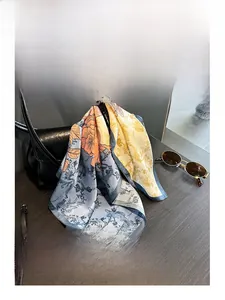Detail eines eleganten bedruckten Seidenschals auf schwarzer Ledertasche mit Retro-Accessoires