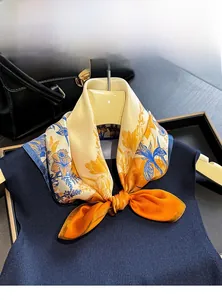 Detail of 100% mulberry silk scarf with floral print tied on a dark knit sweater