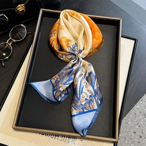 Silk scarf with floral print and pearl ring buckle on luxury black tray display