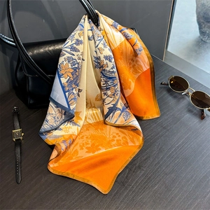 Elegant 100% mulberry silk scarf with floral prints styled on a black leather handbag